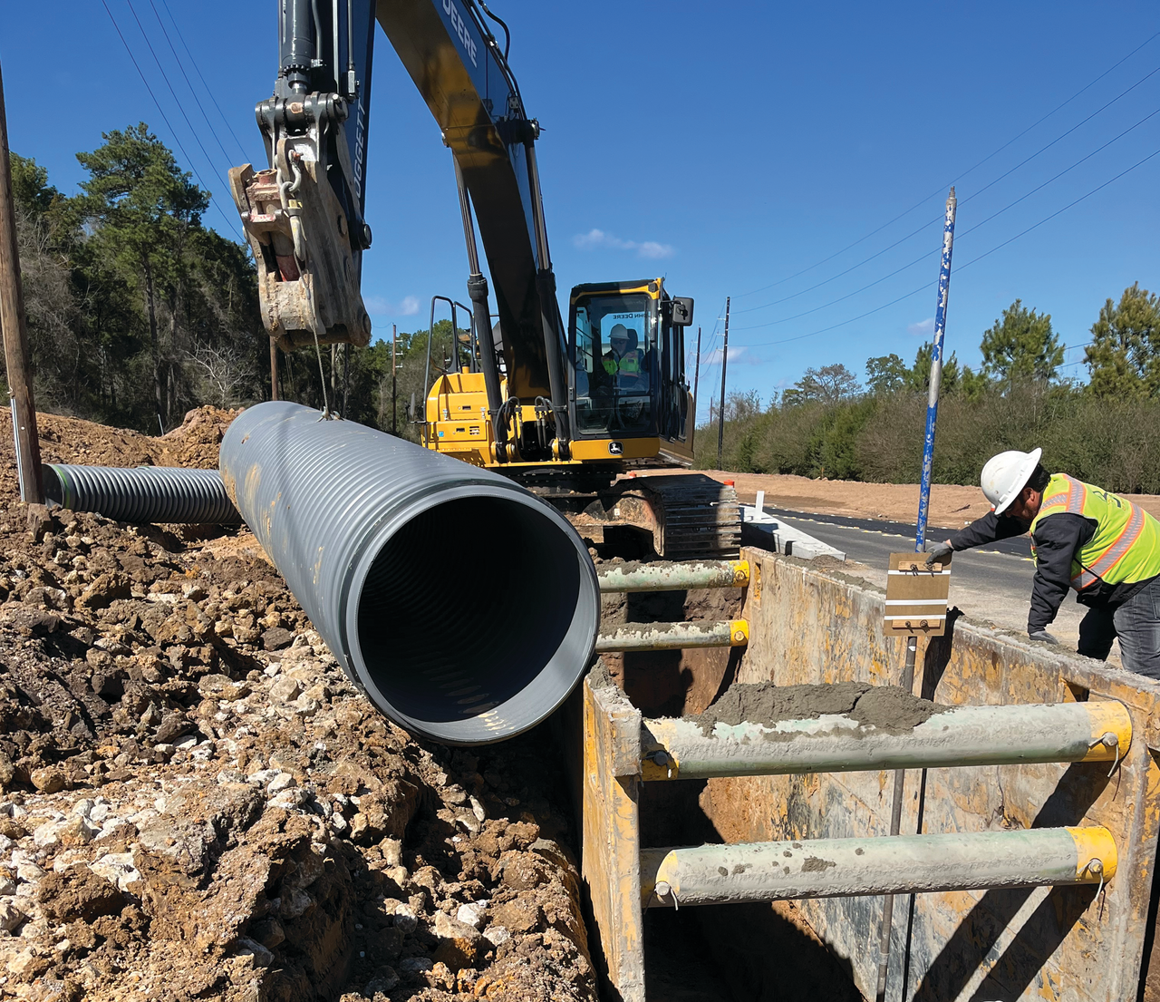 Polypropylene stormwater pipe being installed by construction workers.